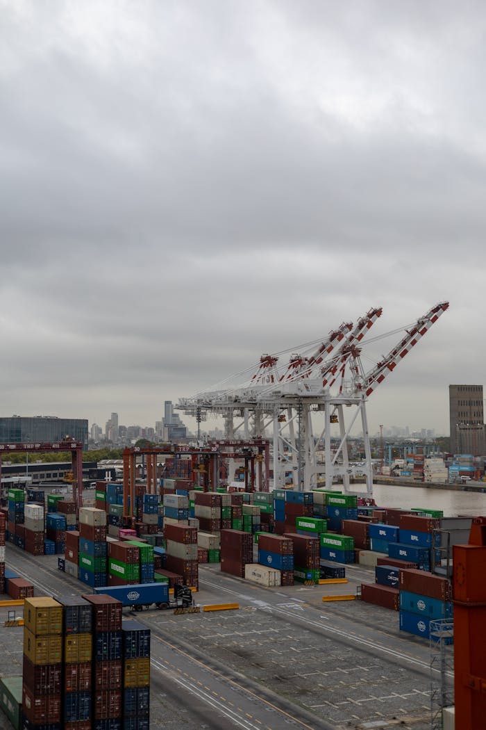 Busy container port with cranes and stacked containers, showing industrial port operations.